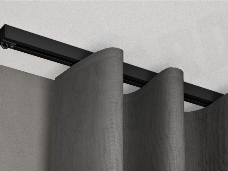 Schwarze 1-läufige Aufputz-Gardinenschiene Modell 450 mit fließendem Vorhang, verdeckt montiert an weißer Decke.