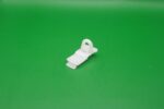 Weißer Endfeststeller aus Kunststoff für Gardinenschienen mit 6 mm Laufbreite auf grünem Hintergrund.