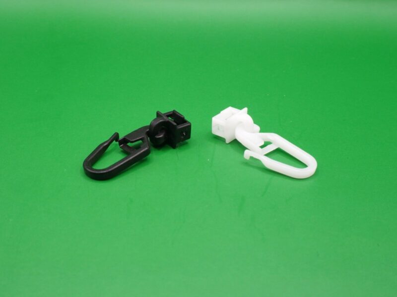 Zwei Gardinengleiter Clic 6 mm mit langem Haken in Schwarz und Weiß, nebeneinander liegend